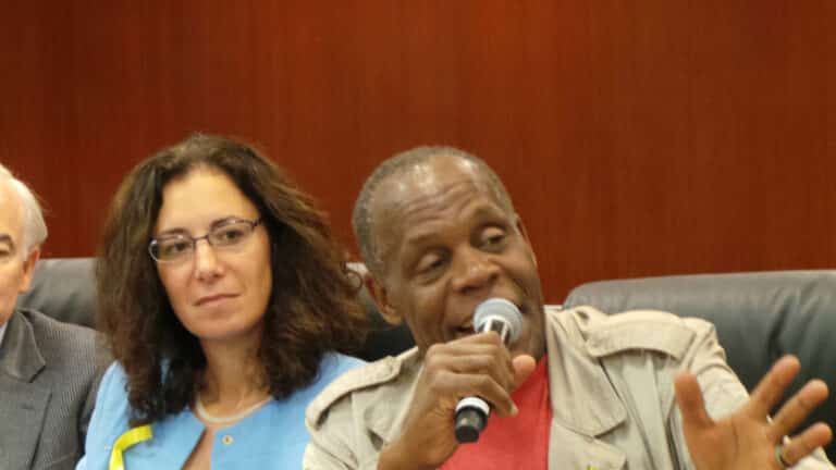 Mara Verheyden-Hilliard and actor Danny Glover. Glover is speaking into a microphone.