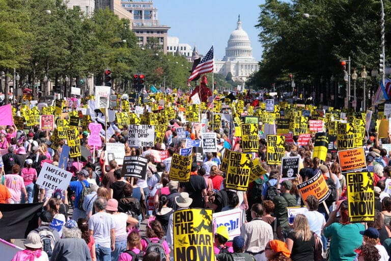 Very large protest in Washington D.C. A lot of people hold signs that read "end the war now"