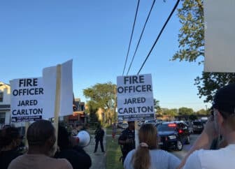 Photo of protestors with signs that read "fire officer Jared Carlton"