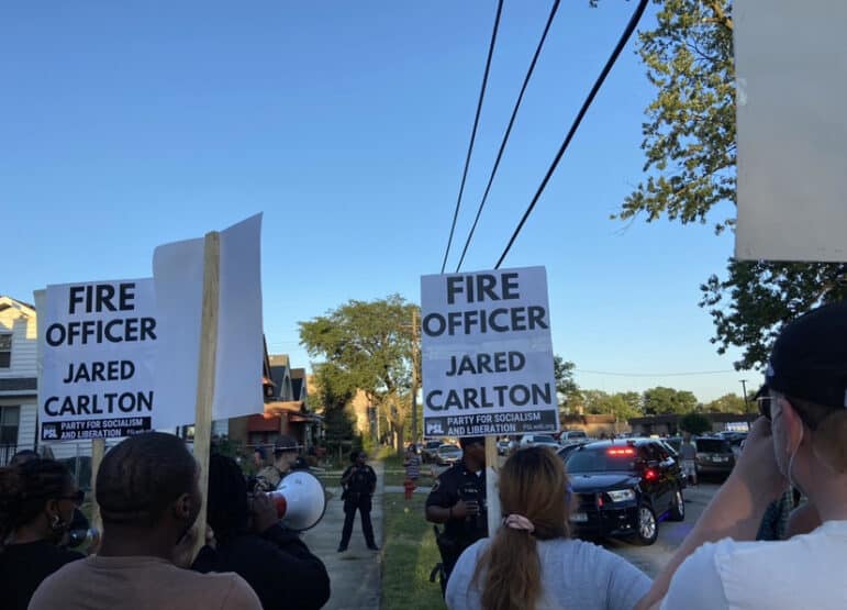 Photo of protestors with signs that read "fire officer Jared Carlton"