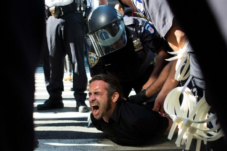 An occupy protestor is held down by police on the Brooklyn Bridge.