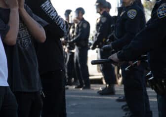 Photo of people standing in front of a line of California Highway Patrolmen.