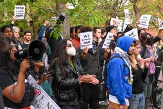 Group of people holding signs that read "We Support Students"