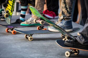 Photo of skateboards and legs from the shin down
